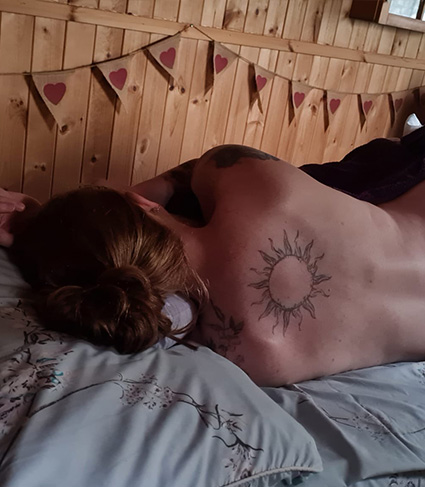 Photograph of a client lying on her side during her massage treatment